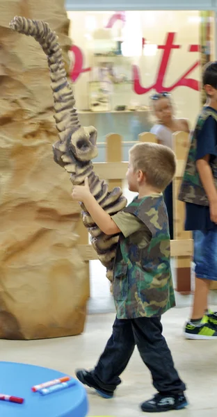 Pojke spelar i mini Jurassic område — Stockfoto