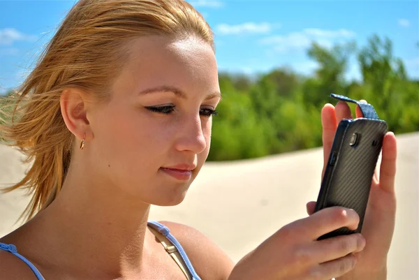 Girl checks her phone — Stock Photo, Image