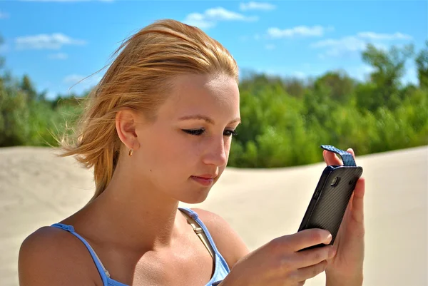 Girl checks her phone — Stock Photo, Image