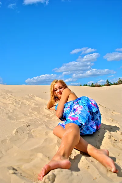 Half naakt meisje bedekt met een weefsel houdingen op het zand — Stockfoto