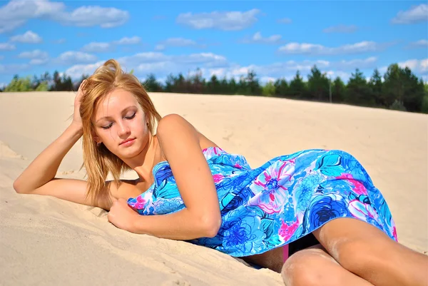 Menina semi-nua coberta com um tecido posa na areia — Fotografia de Stock