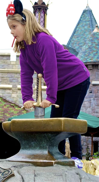 Girl tries to take the sward out of the stone — Stock Photo, Image