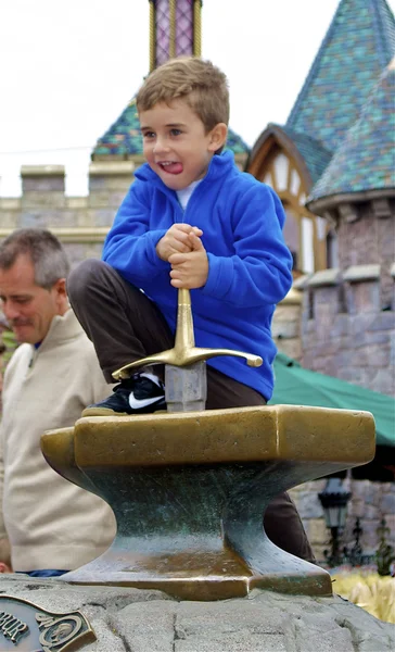 Boy tries to take the sward out of the stone — Stock Photo, Image