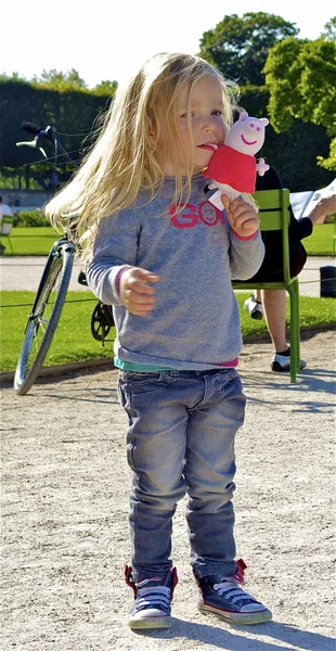 Little blond girl with a toy — Stock Photo, Image