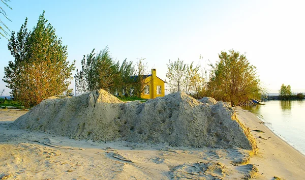 Small yellow huose behind the sand mountain — Stock Photo, Image