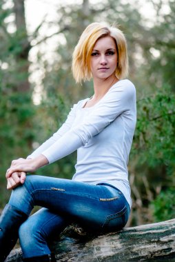 güzel caucasioan model siitting düşmüş ağaç üzerinde teşkil etmektedir.