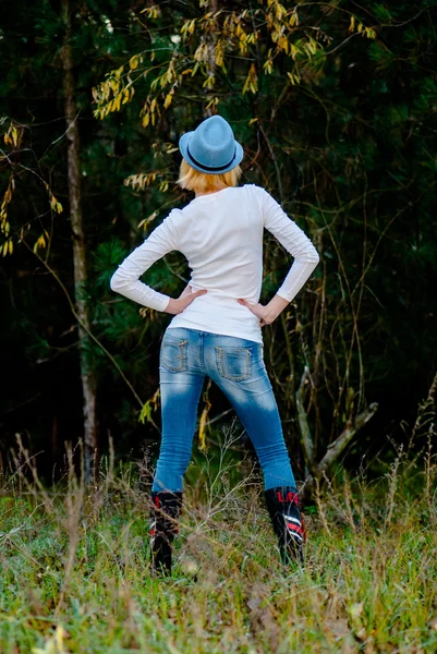 Kaukasiska modell innebär i en hatt och jeans i skogen — Stockfoto