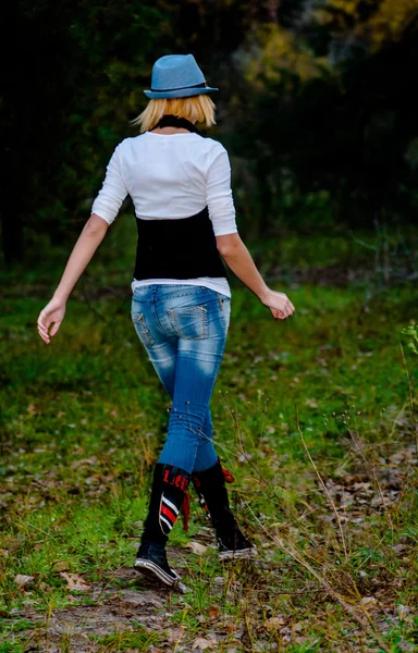 Hermosa chica rubia posa en el bosque con sombrero y ropa de moda — Foto de Stock