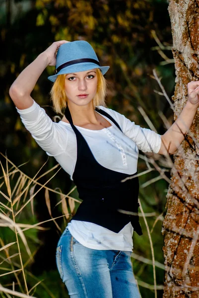 Linda chica con un sombrero gris en el bosque — Foto de Stock