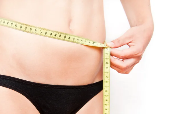 Young woman measuring her stomach — Stock Photo, Image