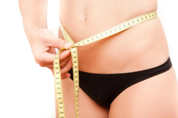 Young woman measuring her stomach — Stock Photo, Image