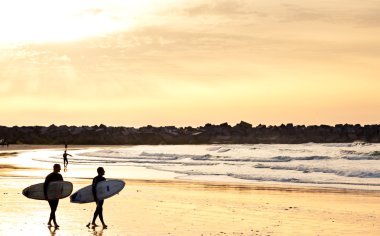 Surfistas tr al playa el atardecer