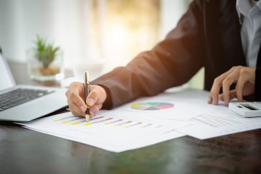 İş adamı iş istatistikleri ve iş grafikleri, bir kalem tutan işadamı ile grafik belgeleri, hisse senedi grafiği çalışma.