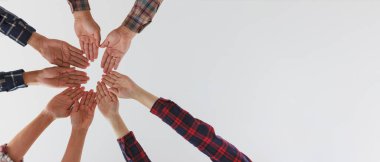 Çeşitli bir grup insan, bir takım çalışması hissini ifade eden bir destek işareti olarak ellerini birbirine bağlıyor. Birlik ve beraberlik. Uzayı kopyala.