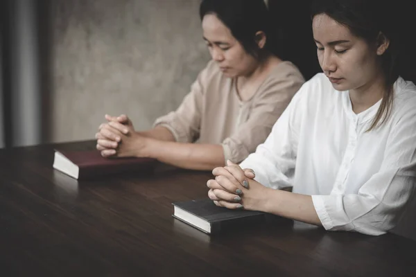 Two women laying hands on the Bible praying to God. Concept of Christianity. .Faith in life. Praying for others. The power of hope or love and loyalty.