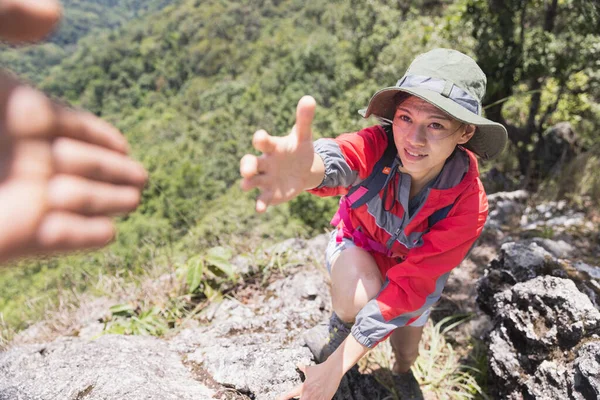 Two people climbing mountain and help, help and assistance concept