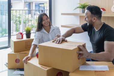 Yeni evlerinde büyük kutuları olan genç bir çift yeni evlerine bir şeyler taşıyorlar..