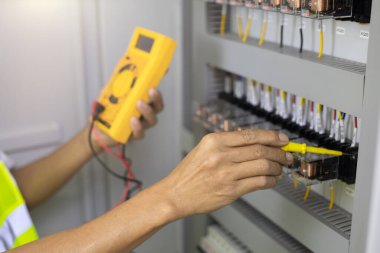 Elektrik mühendisi, kabine kontrolündeki voltaj ve elektrik hattının akımını ölçen bir testçi..