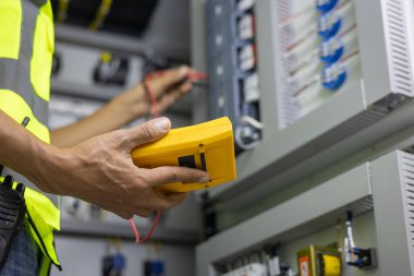 Elektrik mühendisi, kabine kontrolündeki voltaj ve elektrik hattının akımını ölçen bir testçi..