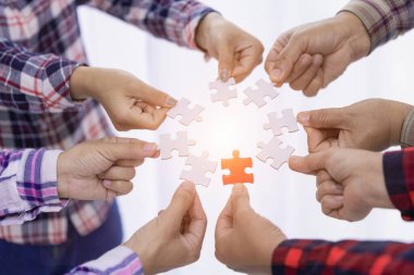 A group of business people assembling jigsaw puzzle. The concept of cooperation, teamwork, help and support in business. Team business success partnership.