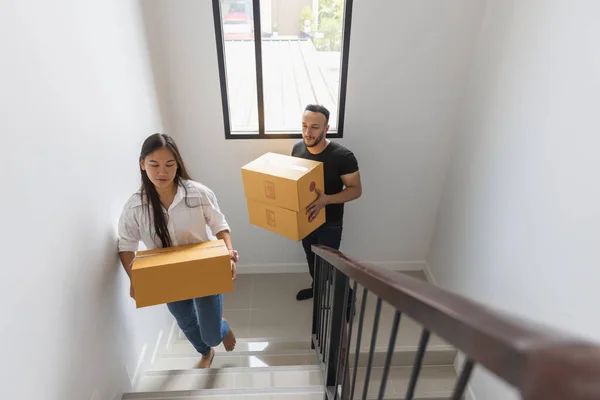 A couple with a big box in their new home. Carrying things into a new home