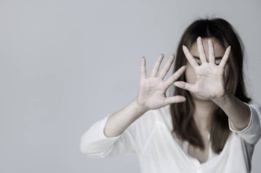 Woman screaming in fear, defending herself with hands in front of her face, scared asian woman in domestic and rape violence