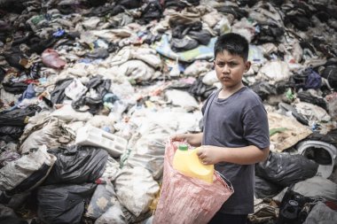  Yoksul bir Hintli çocuk geçimini sağlamak için torbasında plastik şişe topluyor. Yoksulluk, Çocuk Emek ve İnsan Kaçakçılığı..