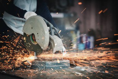 Kıvılcımlar saçan bir çeliğin kesilmesi. Çelik endüstrisi ve atölye konsepti.