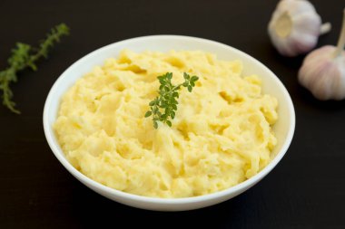 Siyah arka planda ev yapımı sarımsaklı patates püresi..