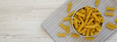 Kuru Rigatoni Makarnası, gri bir kâse, üst manzara. Dümdüz, tepeden, yukarıdan. Boşluğu kopyala.