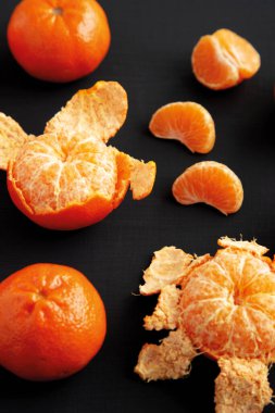 Siyah arkaplanda çiğ organik portakallar, kenar görünüm.