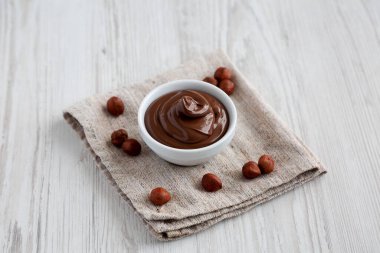 Ev yapımı çikolatalı fındık, beyaz ahşap bir yüzeye, bir kâseye serili..  