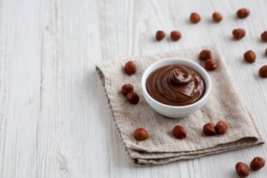 Ev yapımı çikolatalı fındık kabı beyaz ahşap bir masaya serilmiş, yan manzara. Boşluğu kopyala.