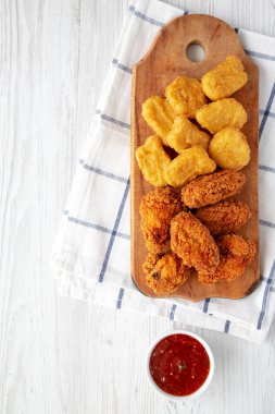 Ev yapımı kızarmış tavuk kanatları ve ekşi soslu tavuk kanadı, ahşap bir tahtanın üstünde. Düz yatıyordu, yukarıdan, yukarıdan. Metin için boşluk.