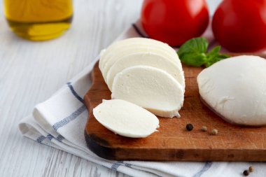 Ev yapımı Mozzarella peyniri, domates, fesleğen ve zeytinyağlı, düşük açılı. Yakın plan..