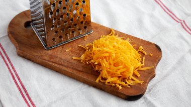 Kırsal ahşap bir tahtanın üzerinde doğranmış Çedar Peyniri..