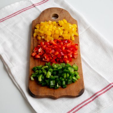 Kırsal tahta üzerinde doğranmış taze renkli biberler, düşük açılı.. 