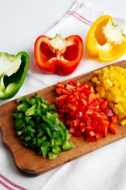 Kırsal tahta üzerinde doğranmış taze renkli biberler, düşük açılı.. 