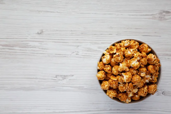 Zelfgemaakte Caramel Popcorn Een Grijze Schaal Een Witte Houten Achtergrond — Stockfoto
