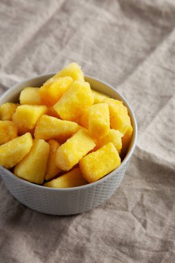 Organik Donmuş Ananas Dilimleri bir kasede, yan görüş. Metin için boşluk.
