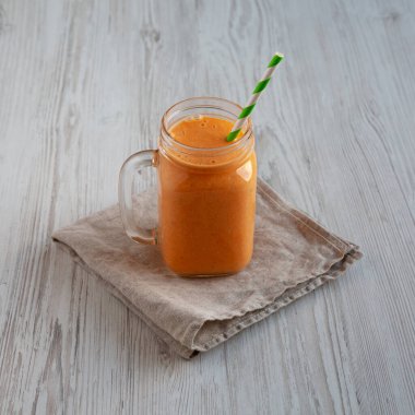 Ev yapımı havuç Clementine Muz Smoothie cam kavanozda, yan görüş.