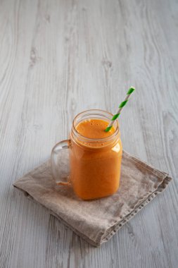 Cam kavanozda ev yapımı havuç Clementine Muzlu Smoothie; yan görüş. Boşluğu kopyala.