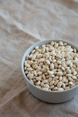 Gri bir kasede çiğ organik kuru fasulye, yan görüş. Metin için boşluk.