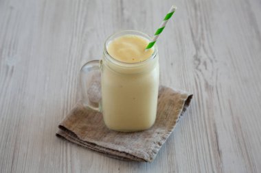 Ev yapımı Pineapple Mango Muzlu Smoothie cam kavanozda, düşük açılı..