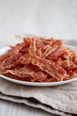Beyaz tabakta kızarmış domuz pastırması, yan görüş. Yakın plan..