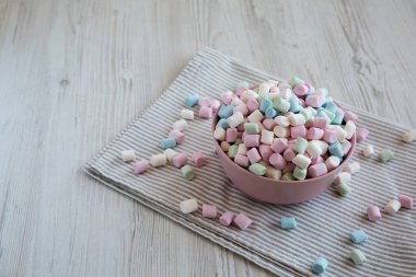 Pembe kâse içinde Gökkuşağı Fruity Mini Marshmallowları, yan görüş. Boşluğu kopyala.