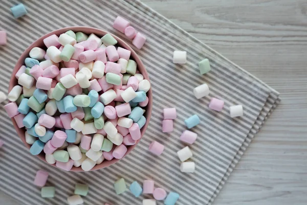 Gökkuşağı Fruity Mini Marshmallow 'u pembe kasede, en iyi manzara. Dümdüz, tepeden, yukarıdan. Metin için boşluk.
