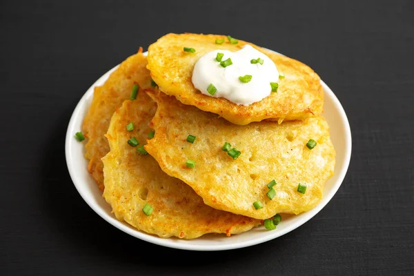 Ev yapımı İrlanda patatesli krep, siyah arka planda bir tabakta, yan görünüşte..