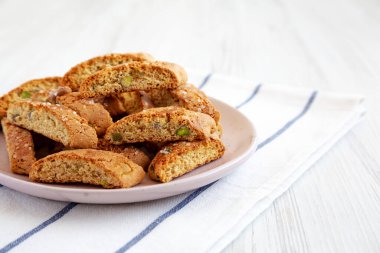 Ev yapımı İtalyan Cantuccini, yanında da Pistachios ve Citron tabağı. Çıtır Pistachio ve Citron Kurabiyeleri. Boşluğu kopyala.
