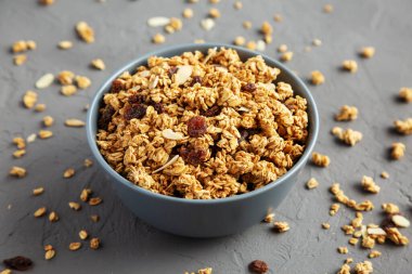 Gri arka planda kuru üzüm ve bademli ev yapımı granola.. 